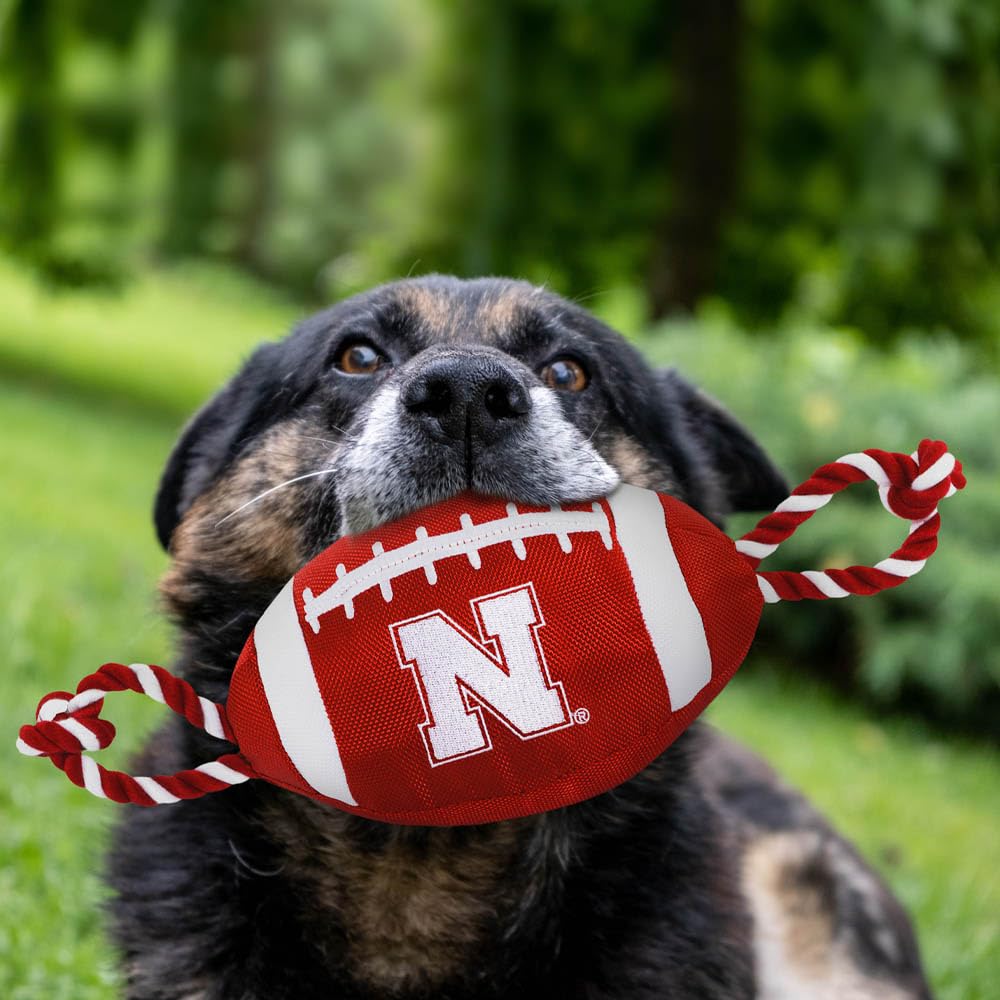Pets First NCAA Nebraska Cornhuskers Football Dog Toy, Tough Quality Nylon Materials, Strong Pull Ropes, Inner Squeaker, Collegi